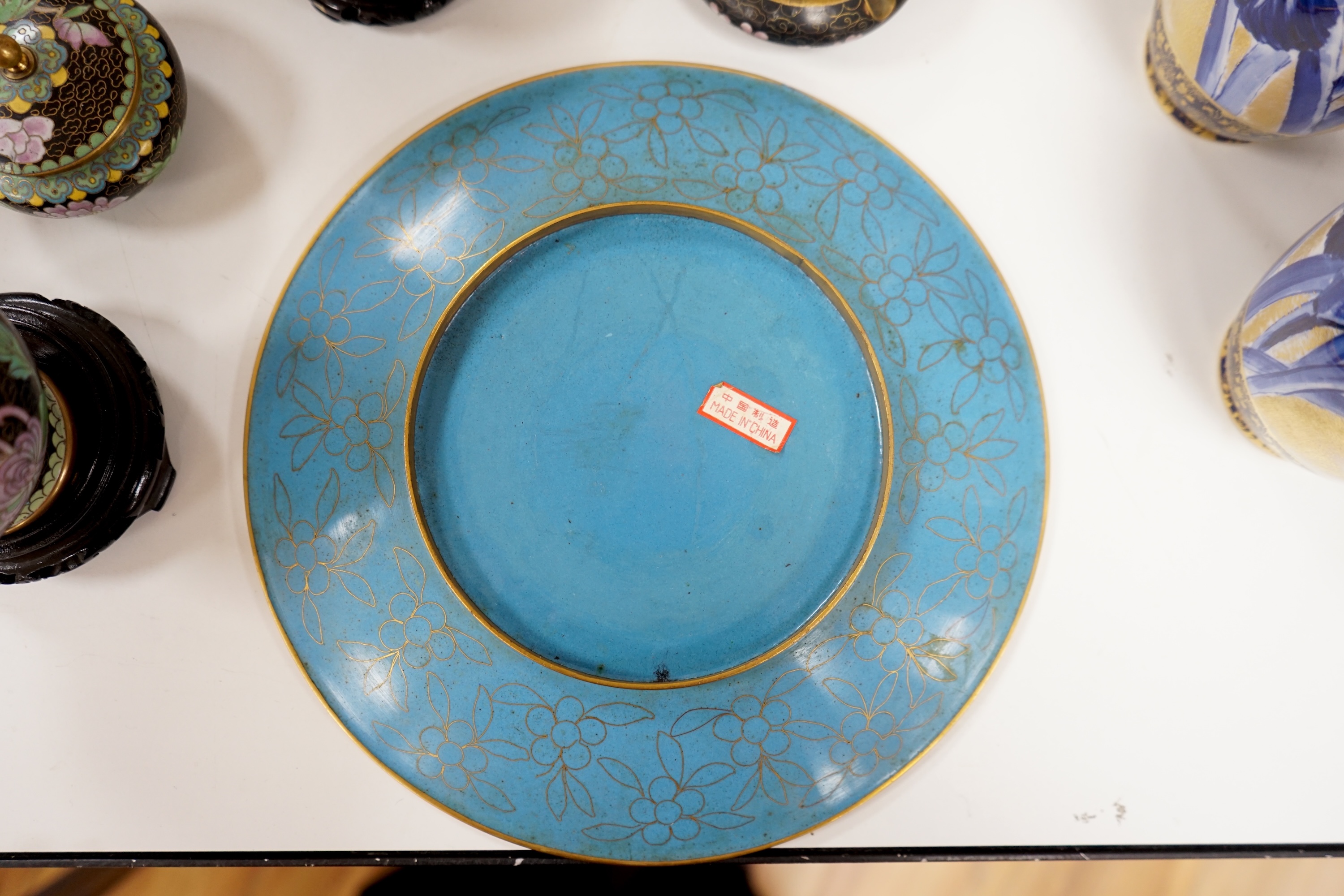 A collection of Chinese cloisonné enamel vessels, some with stands, all worked on a black background in floral designs, plate 26cm diameter. Condition - good